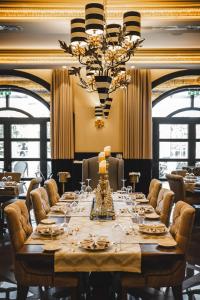 a large table in a restaurant with chairs and a chandelier at Kyniska Palace Conference & Spa in Mystras
