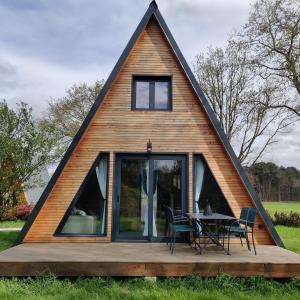 a house with a triangular roof with a table on a deck at Tipi Dakota des monteaux in Vivy