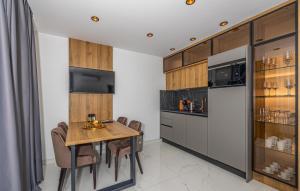 a kitchen with a wooden table and a refrigerator at Awesome Apartment In Crikvenica in Crikvenica