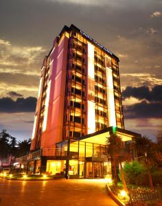 un edificio iluminado con palmeras delante de él en North Point Hotel, en Samsun