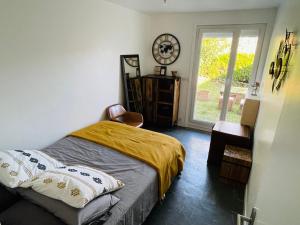 a bedroom with a bed and a clock on the wall at Cozy villa in Aulnay-sous-Bois