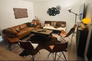 a living room with a couch and a table and chairs at Cozy villa in Aulnay-sous-Bois