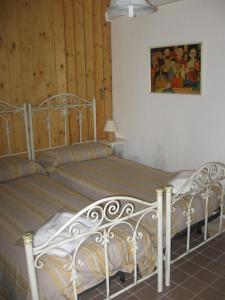 a bedroom with two beds and a painting on the wall at Agriturismo Il Casotto in Maida