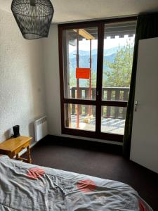 a bedroom with a bed and a window with a view at T2 Praloup 1500 in Uvernet