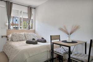 - une chambre avec un lit et une table avec un vase dans l'établissement Estudio con wifi piscina y parking en Benalmádena - ACUARIO 5, à Benalmádena 22 autres photos