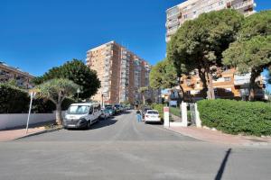 une rue avec des voitures garées sur le bord de la route dans l'établissement Estudio con wifi piscina y parking en Benalmádena - ACUARIO 5, à Benalmádena