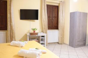 sypialnia z 2 łóżkami i telewizorem na ścianie w obiekcie The Maze Vibo B&B w mieście Vibo Valentia