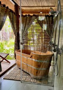a wooden tub in a room with a shower at Anne House Bac Ha in Bắc Hà
