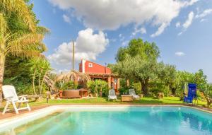 a swimming pool in front of a house with a red house at Casa Blandina in Menfi