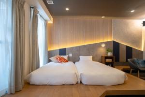 a bedroom with two white beds and a window at WAYFARER Kyoto Shijo in Kyoto +97 photos