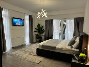 a bedroom with a bed and a television and a chandelier at hotel le manoir in Gostivar