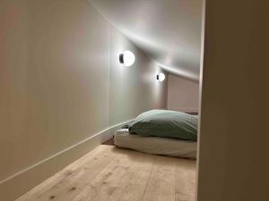 a bedroom with a bed and two lights on the wall at Charmante maison de ville à 10' du centre de Lyon in Sainte-Foy-lès-Lyon