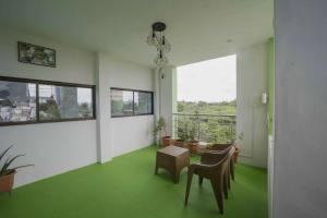 a room with a green floor and chairs and a window at Sai Guest House in Tiruvannāmalai