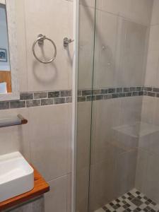 a shower with a glass door next to a sink at Mike's Place 1 in Mossel Bay
