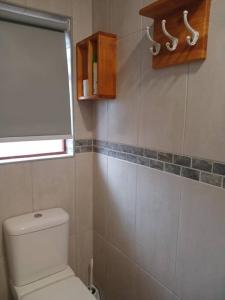a bathroom with a white toilet and a window at Mike's Place 1 in Mossel Bay +2 photos