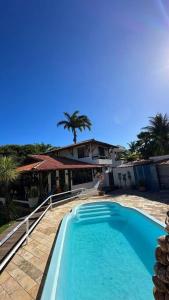 ein großer blauer Swimmingpool vor einem Haus in der Unterkunft Casarão 100 metros da praia in Barra de São Miguel + 6 Fotos