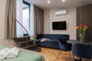 a hotel room with a bed and a couch and a table at H77 Apartments - Maison D'Art Collection in Rome