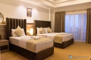 a hotel room with two beds and a window at Serenity Studio Apartment by Ocean Breeze in Negombo +32 photos