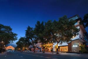 a street at night with trees and a building at Return to Emei Hotel in Baoguosi