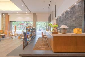 a lobby with a library with chairs and bookshelves at Return to Emei Hotel in Baoguosi