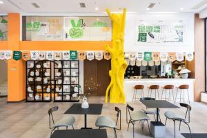 a restaurant with tables and chairs and a yellow tree at Return to Emei Hotel in Baoguosi +18 photos