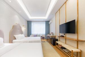 a hotel room with two beds and a flat screen tv at Return to Emei Hotel in Baoguosi
