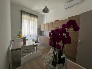 a kitchen with a vase with purple flowers in it at Mari&Monti 2 in Sapri