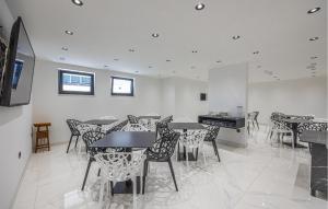 a dining room with tables and chairs and a television at Nice Apartment In Crikvenica in Crikvenica