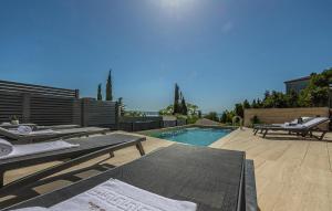 a backyard with a swimming pool and a patio with tables at Nice Apartment In Crikvenica in Crikvenica +26 photos