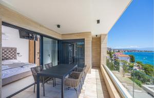 a balcony with a table and chairs and a bed at Nice Apartment In Crikvenica in Crikvenica