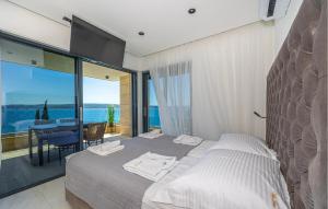 two beds in a bedroom with a view of the ocean at Nice Apartment In Crikvenica in Crikvenica