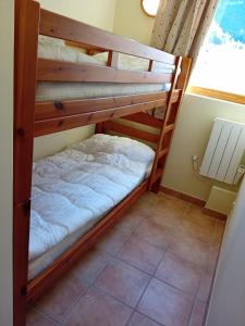 two bunk beds in a room with a window at Terrasses D 306 PARC NAT VANOISE appart 6 pers in Val Cenis