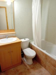 a bathroom with a toilet and a sink and a tub at Terrasses E 309 PARC NAT VANOISE appart 6 pers in Val Cenis