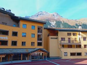 a hotel with a mountain in the background at Terrasses E 309 PARC NAT VANOISE appart 6 pers in Val Cenis