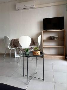 Una sala de estar con una mesa y sillas y un televisor. en Appartement T2 - 2 a 4 Personnes - Vue sur Mer - 4CAPE2N10, en Narbonne-Plage