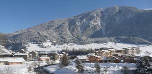 a town covered in snow in front of a mountain at Terrasses D 101 PARC NAT VANOISE appart 4 pers in Val Cenis +6 photos