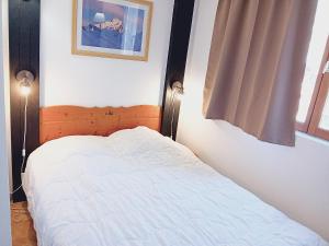 a bedroom with a white bed with two lights at Terrasses E 305 PARC NAT VANOISE appart 6 pers in Val Cenis