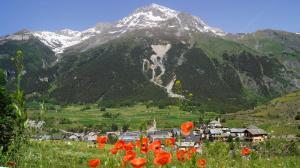 a village in a field with a mountain at Terrasses D 406 PARC NAT VANOISE appart 4 pers in Val Cenis