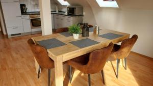 einen Holztisch mit Stühlen in der Küche in der Unterkunft Am Sternberg 227 in Frankenau