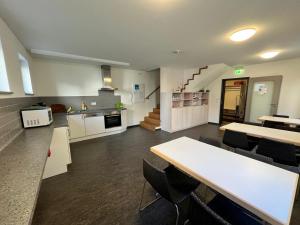 a large kitchen and dining room with a table and chairs at Velo-Pension Mainbernheim in Mainbernheim