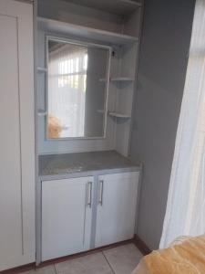 een witte kast met een raam in een kamer bij Kamga House in Bloemfontein