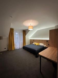 a bedroom with a bed and a table in it at "Озерний край" in Pustomyty