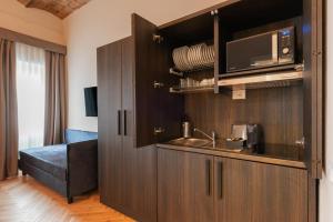 a kitchen with a sink and a microwave at H77 Apartments - Maison D'Art Collection in Rome