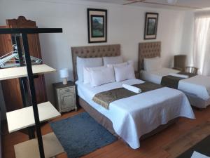 Un dormitorio con una cama grande y una habitación con un sofá. en Mrakes Guesthouse, en Odendaalsrus