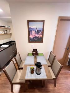 a table and chairs in a room with a kitchen at Apartamento 1 quarto, com garagem no centro próximo Hospital de Caridade in Santa Maria