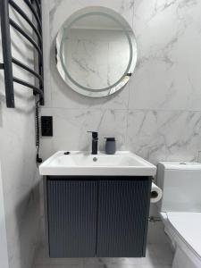 a white bathroom with a sink and a mirror at "Озерний край" in Pustomyty