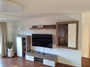 Una sala de estar con un televisor de pantalla plana en una pared. en Schönblick, en Freudenstadt