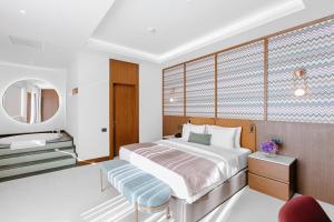 a bedroom with a bed and a sink and a mirror at Qafqaz Riverside Hotel in Gabala
