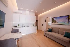 a living room with a couch and a kitchen at Summer Depo in Sarandë