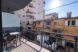 a balcony with a table and chairs and buildings at Summer Depo in Sarandë